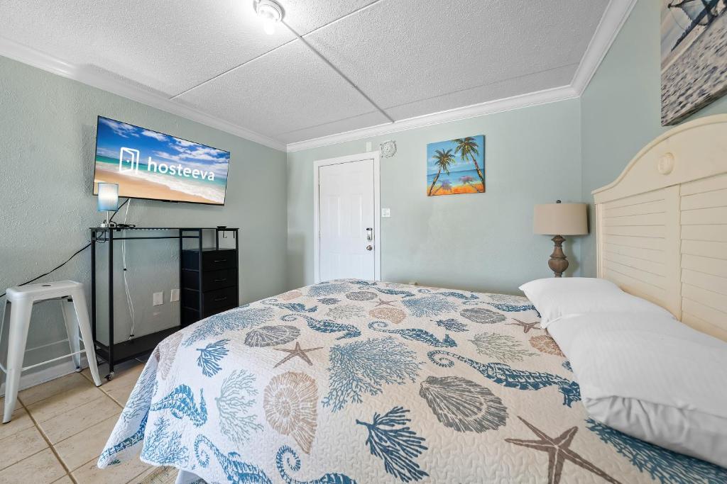 a bedroom with a bed and a tv on the wall at Beachview 312 in Gulf Shores