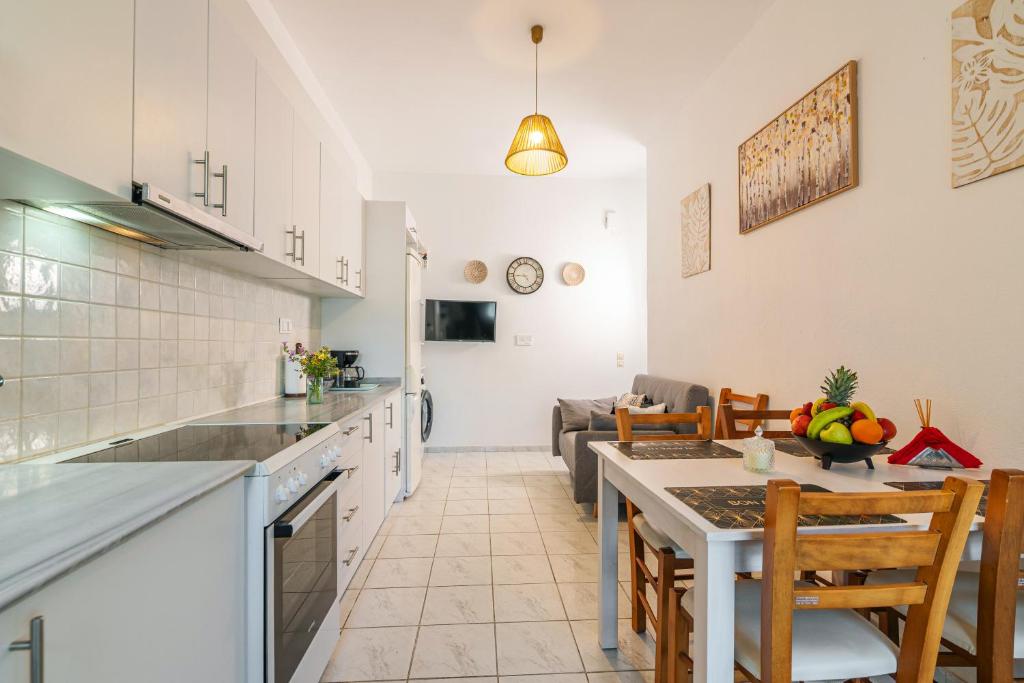 アギア・ペラギアにあるAriella, Cozy Apartment Near the Beachのキッチンとテーブルとソファのあるリビングルーム
