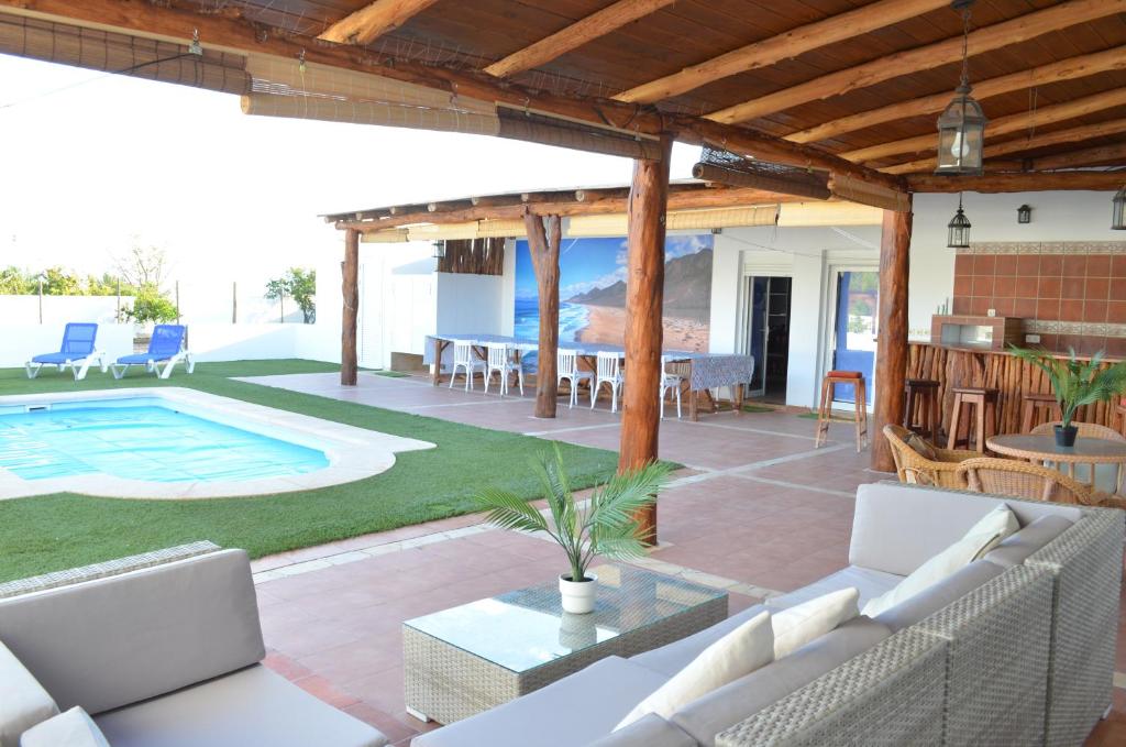 a patio with white furniture and a swimming pool at Villa Mónica by Mirador de Sotavento Apartments in Cardón