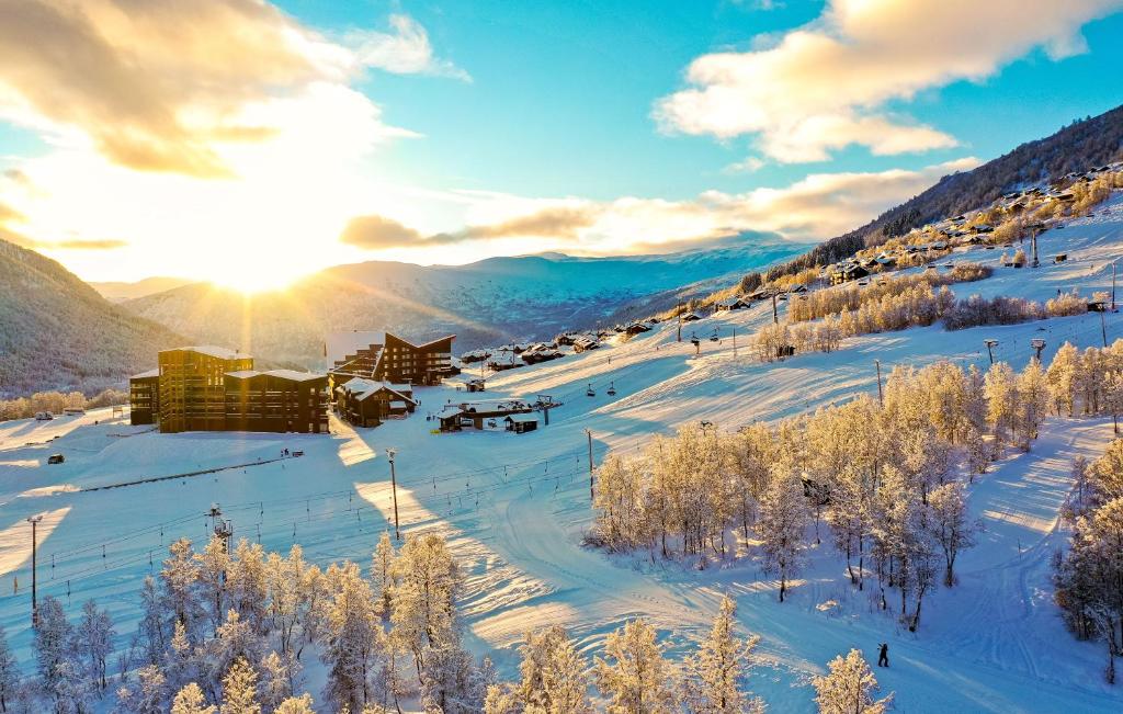 a ski lodge in the snow with the sun setting at Myrkdalen Resort Hotel in Myrkdalen