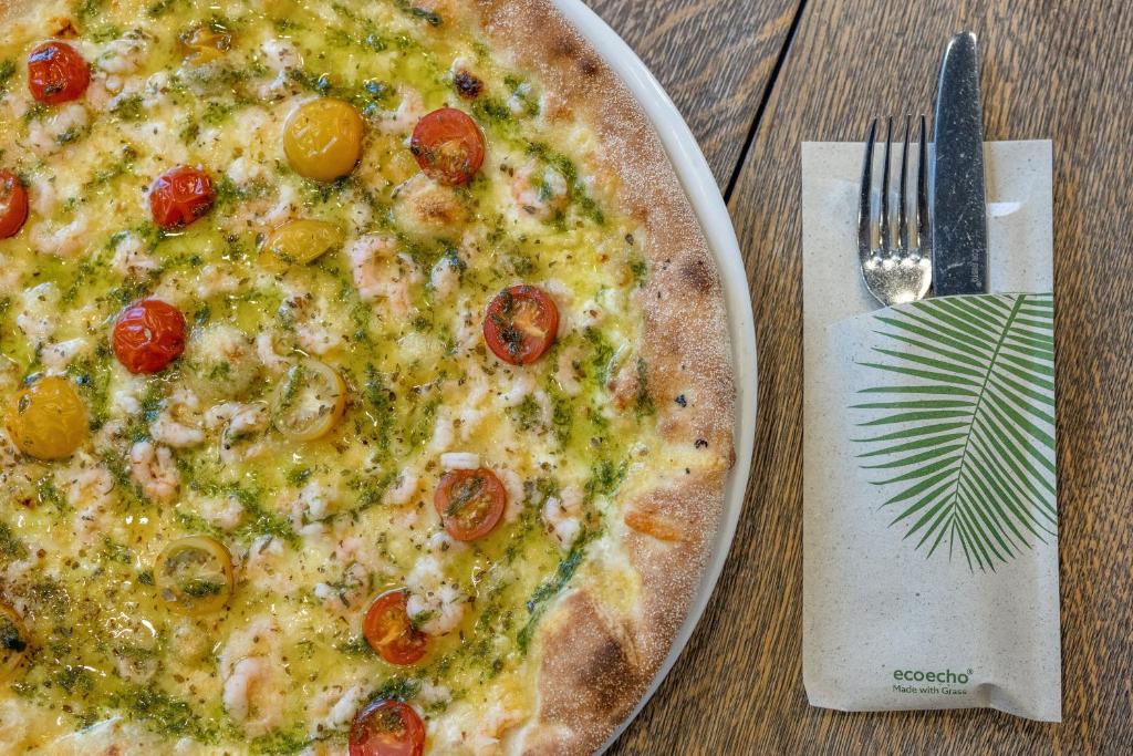 a pizza on a plate on a table with a fork at Myrkdalen Resort Hotel in Myrkdalen