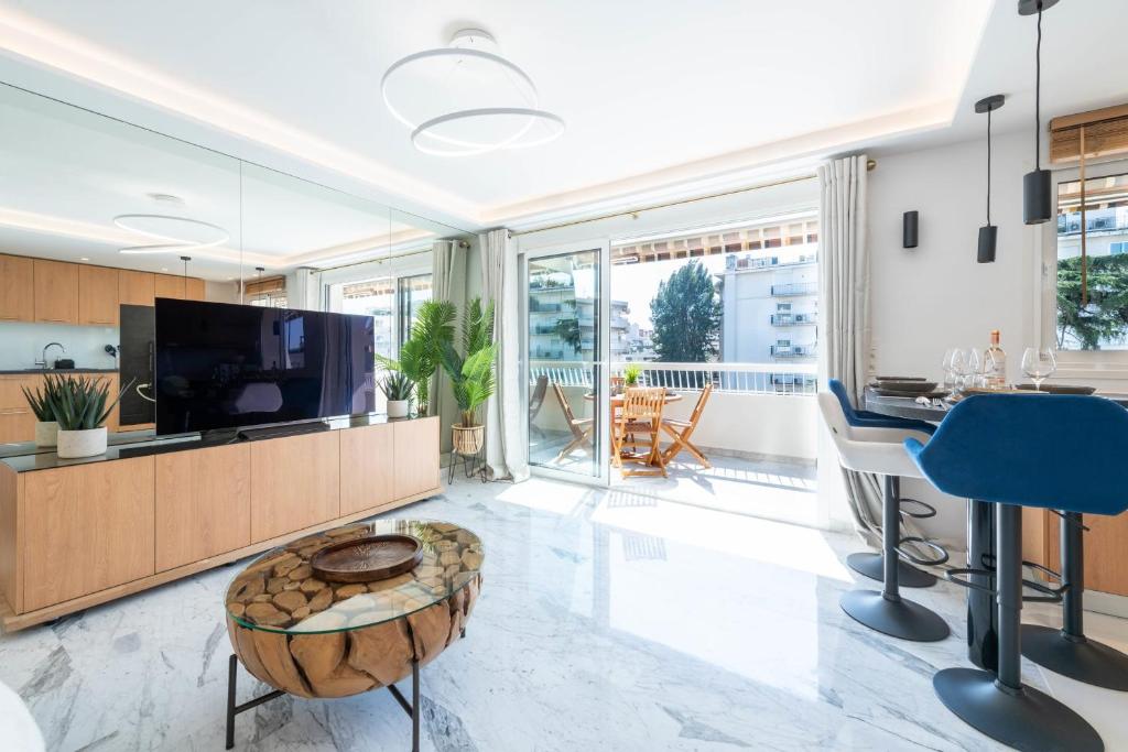 un salon avec une télévision et une table dans l'établissement Spacious 1-Br Apartment with Terrace Heart of Cannes, à Cannes