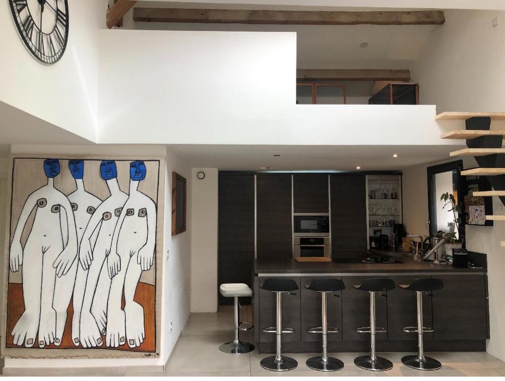 une cuisine avec un bar et des tabourets. dans l'établissement Maison indépendante à 100 m de la plage, à Six-Fours-les-Plages