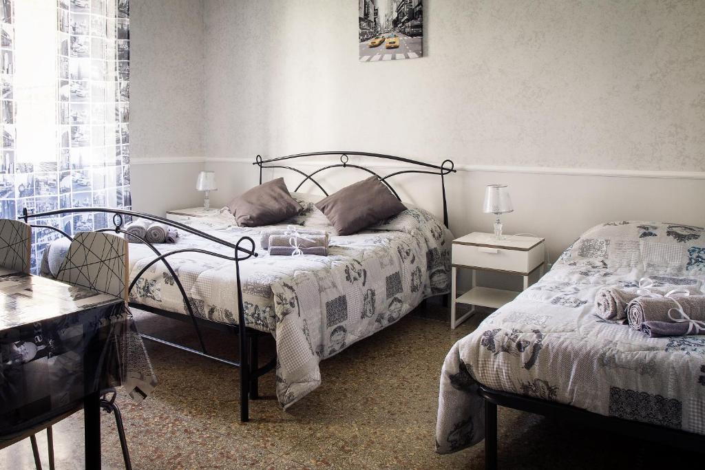 ローマにあるAppartamento Residence Sole e Lunaのベッドルーム1室(ベッド2台、テーブル、窓付)