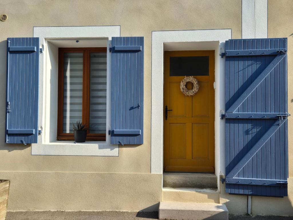 une maison avec des volets bleus et une porte jaune dans l'établissement Soleil Marin à Gruissan Village, à Gruissan