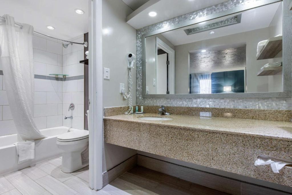 un bagno con lavandino, water e specchio di Quality Inn Carolina Oceanfront a Kill Devil Hills