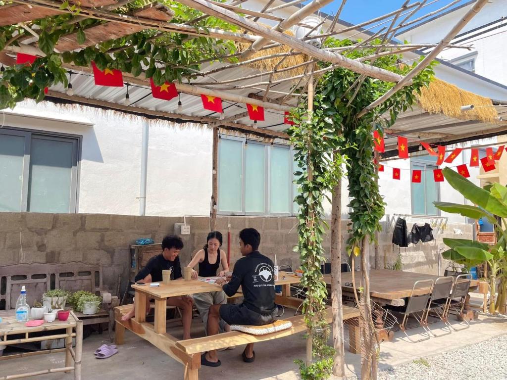 a group of three people sitting at a table at Homestay Nhà Trong Hẻm Đảo Phú Quý in Cu Lao Thu