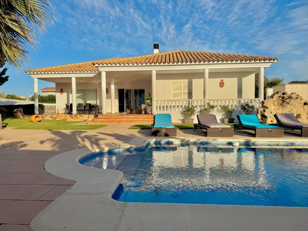 a house with a swimming pool in front of a house at Villa Coral in Cala en Blanes