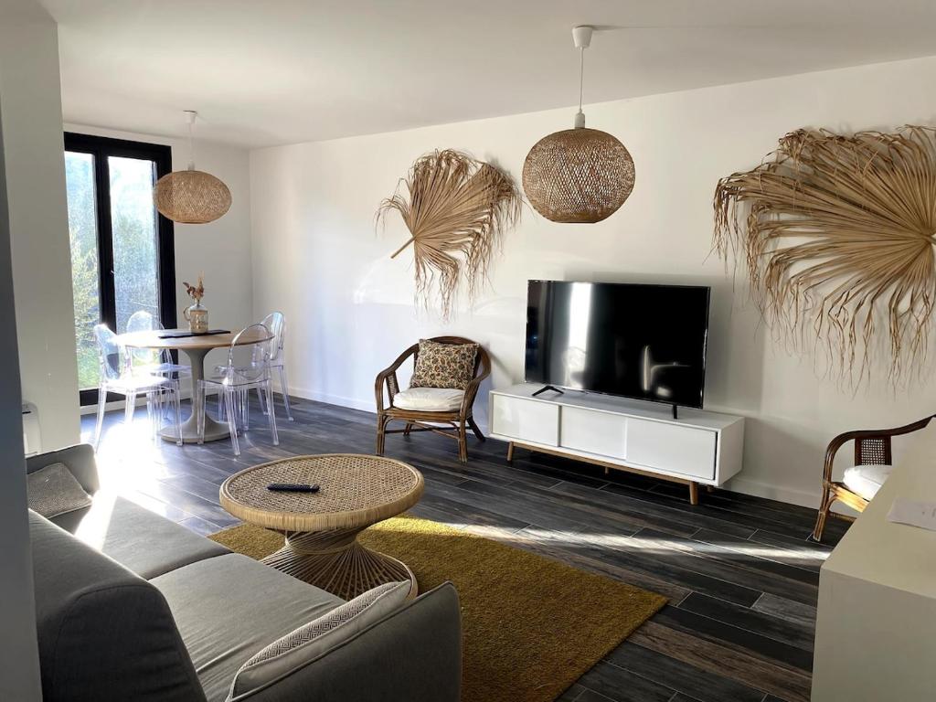 un salon avec un canapé et une télévision à écran plat dans l'établissement Tout confort centre de Saint Florent avec jardin, à Saint-Florent