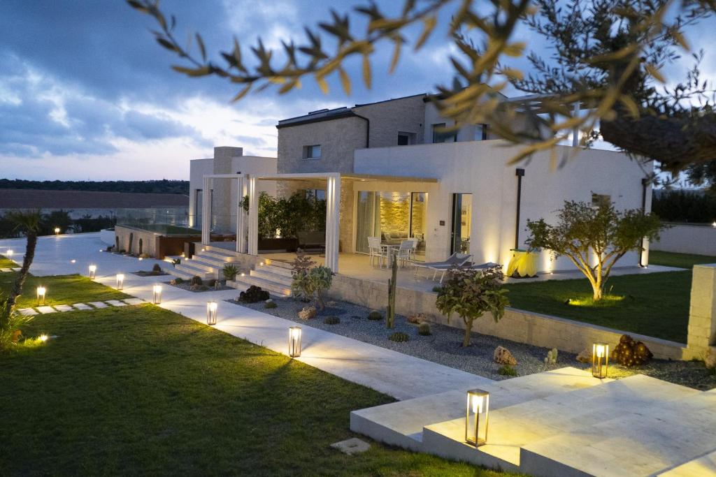 a house with lights on the lawn at night at Shalamu Luxury Apartments in Rosolini