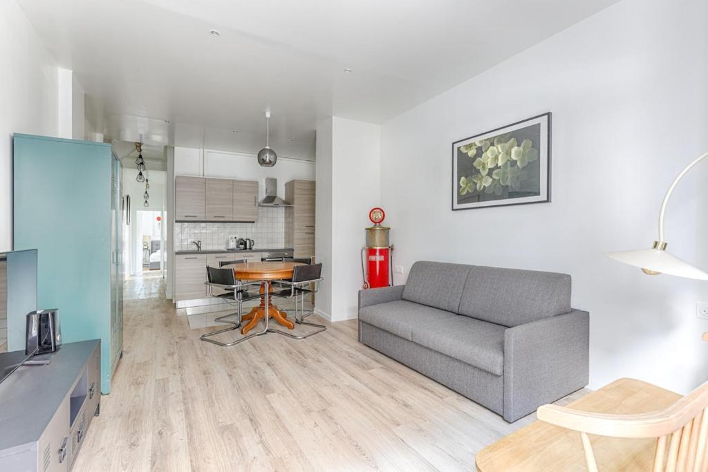 un salon avec un canapé et une table dans l'établissement Traversière III Boulogne-Billancourt Apartment4P, à Boulogne-Billancourt
