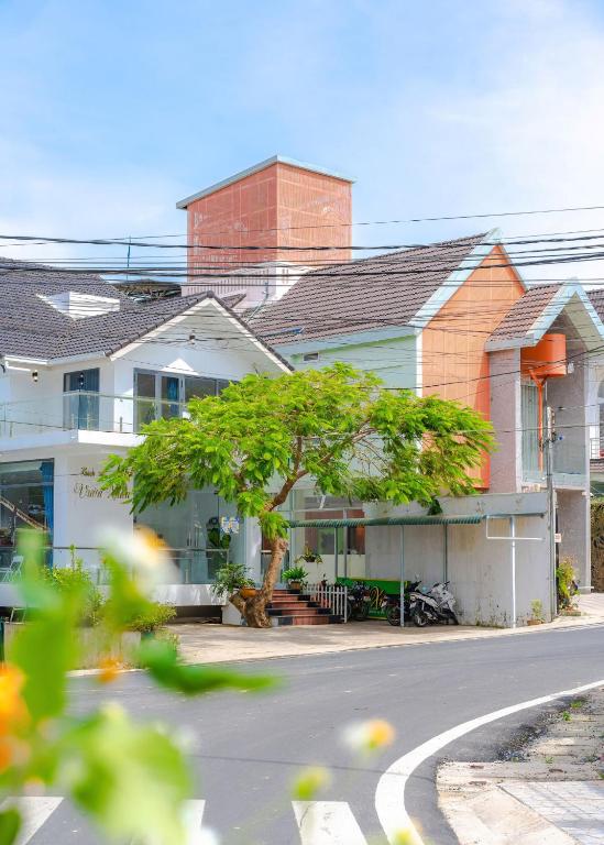 a house with a tree in front of a street at Ami Villa Dalat in Da Lat