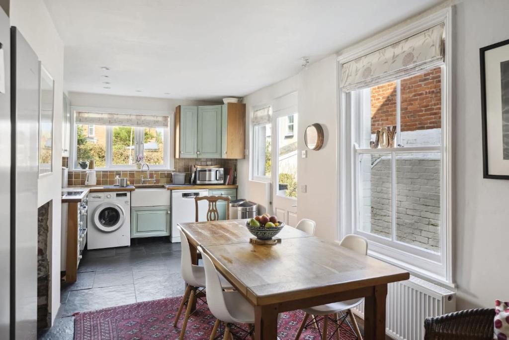a kitchen with a wooden table and a dining room at Beautiful Victorian Home on Peaceful Green Square in Exeter