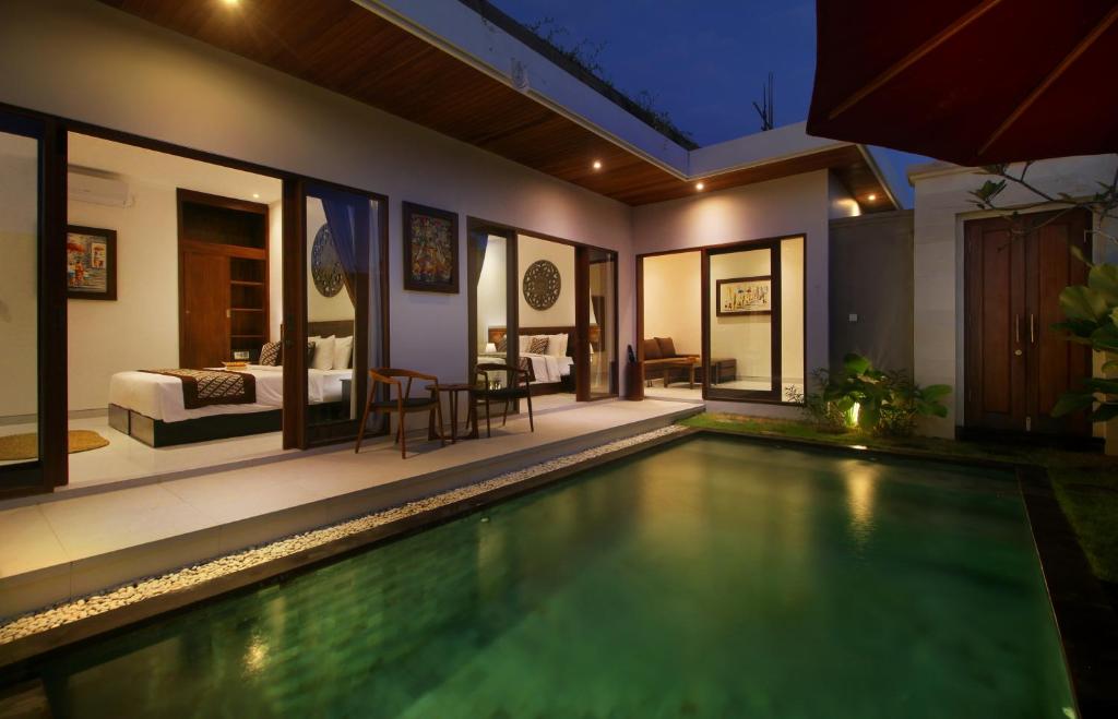 a villa with a swimming pool and a bedroom at Bougainnvillea Villa Cemagi by Parigata in Cemagi