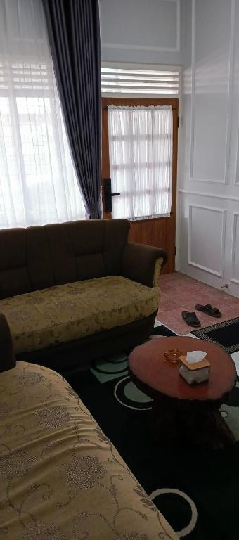 a living room with a couch and a table at Soraya Homestay Malang in Rampal