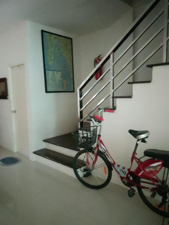 a bike parked in a room with a staircase at Katika Home 2 in Ban Khlong Haeng