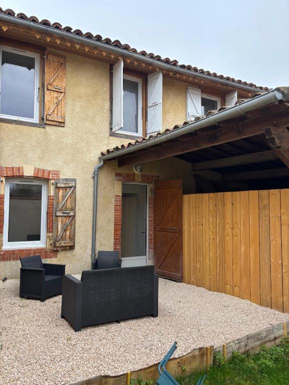 une maison avec une clôture et une terrasse dans l'établissement Charmante maison de village, à Masseube