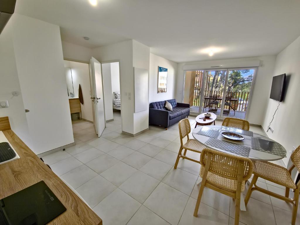 une salle à manger et un salon avec une table et des chaises dans l'établissement Kalia Residence New appartment with Terrace, à Cavalaire-sur-Mer