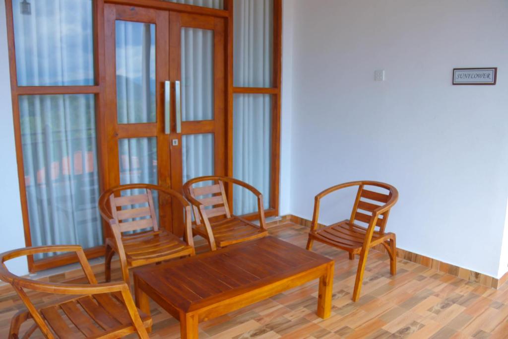 comedor con 3 sillas y mesa de madera en Mountain View Villa Kurunegala, en Kurunegala