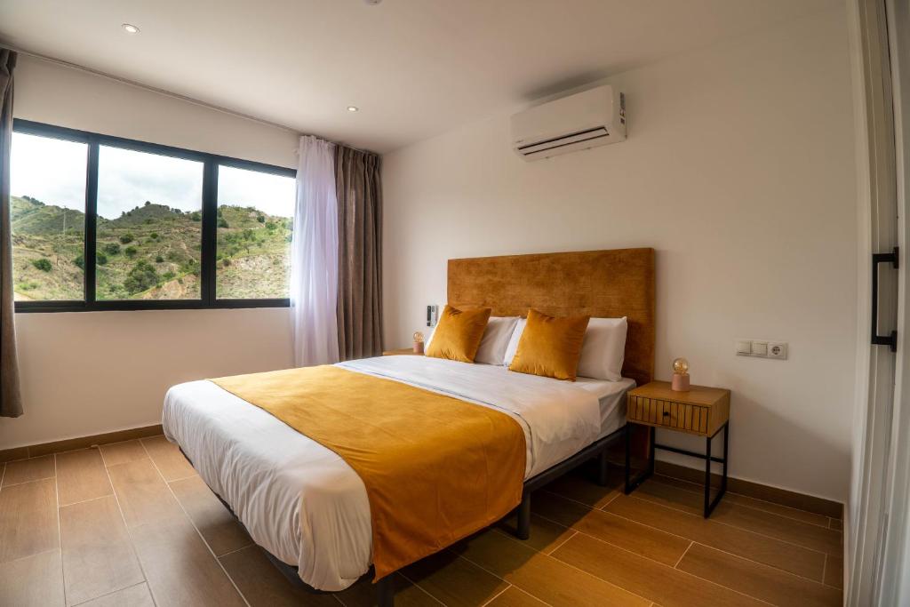 a bedroom with a large bed and a large window at Novaotel Malaga in Málaga