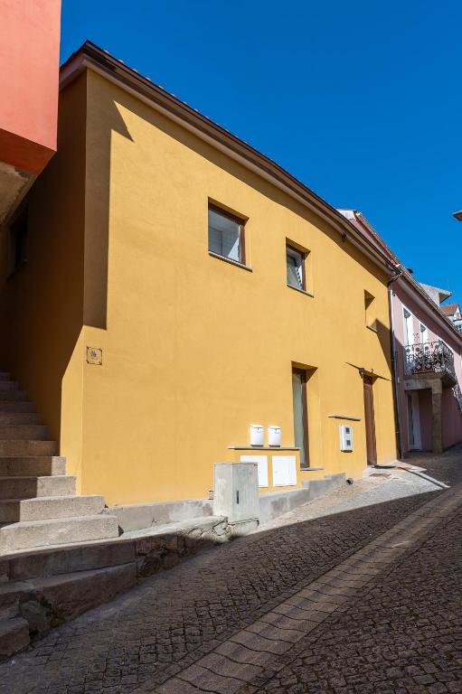 a yellow building with stairs on the side of it at Casinha da Avó Ana in Sever do Vouga