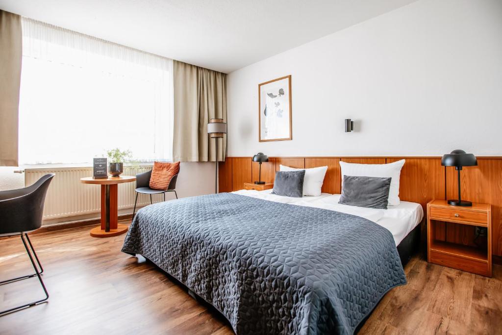 エアフルトにあるHotel Gartenstadt Erfurtのベッドと机があるホテルの部屋