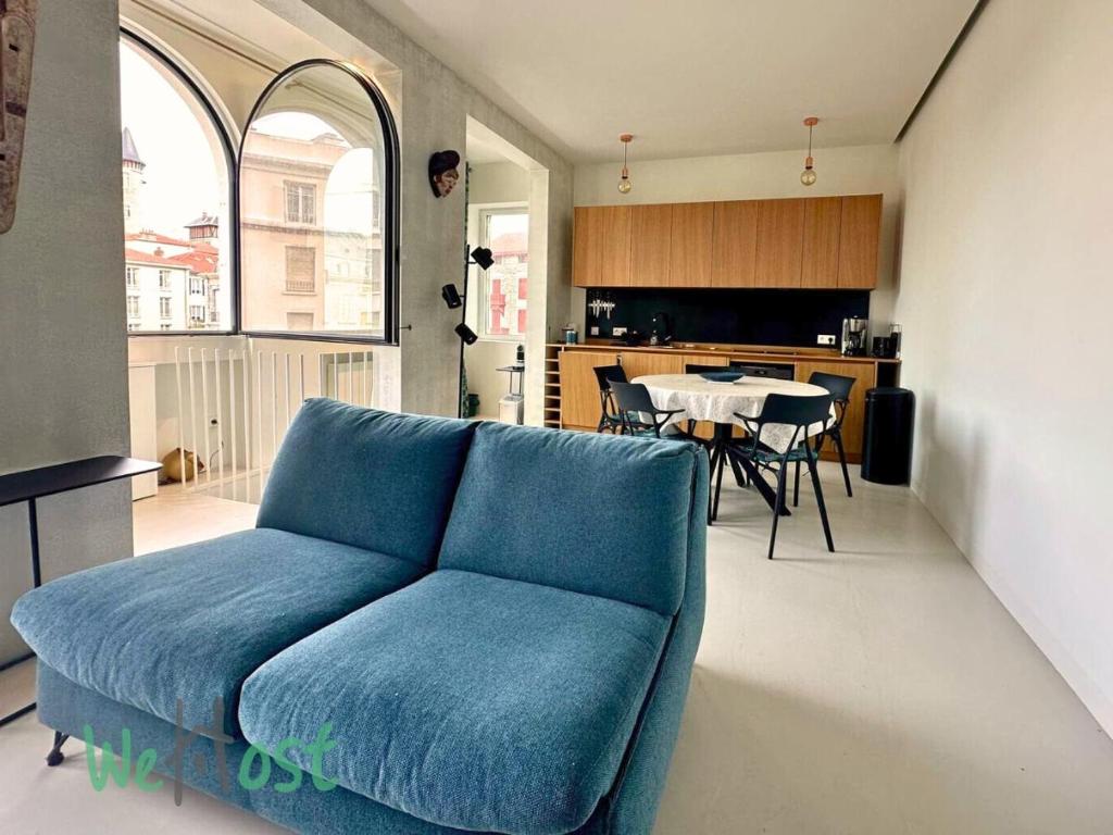 un canapé bleu dans un salon avec une table dans l'établissement Vieux-Port - LB - PB - Vieux Beautiful apartment beach 4 people, à Biarritz