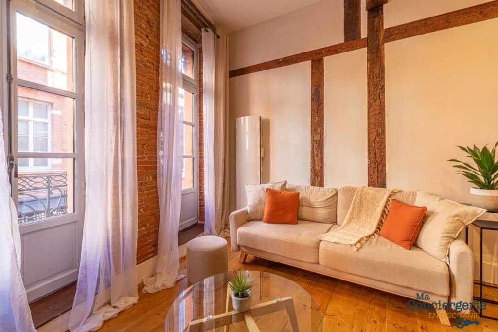 un salon avec un canapé et quelques fenêtres dans l'établissement Leon - Capitole - Hypercentre Ville - Métro, à Toulouse
