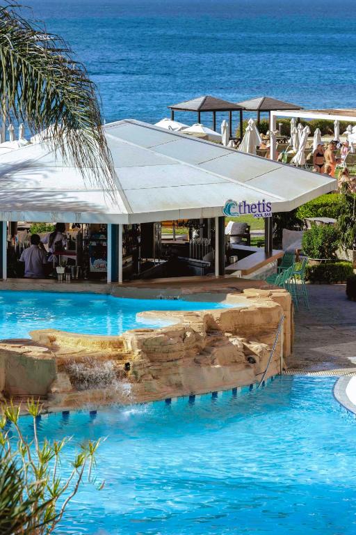 a resort with a swimming pool next to the ocean at Leonardo Cypria Bay in Paphos