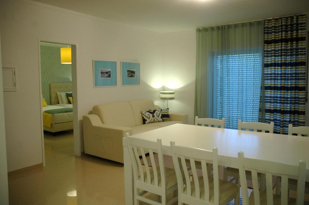 a living room with a couch and a dining room table at Hotel Dom Lourenco in Areia Branca