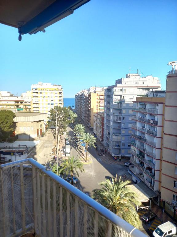 a balcony view of a city with palm trees and buildings at Victoria, 8-22 in Cullera
