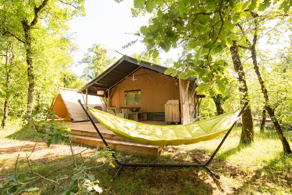 una hamaca frente a una cabaña en el bosque en Lodge Holidays - Les 3 Cantons, en Saint-Antonin