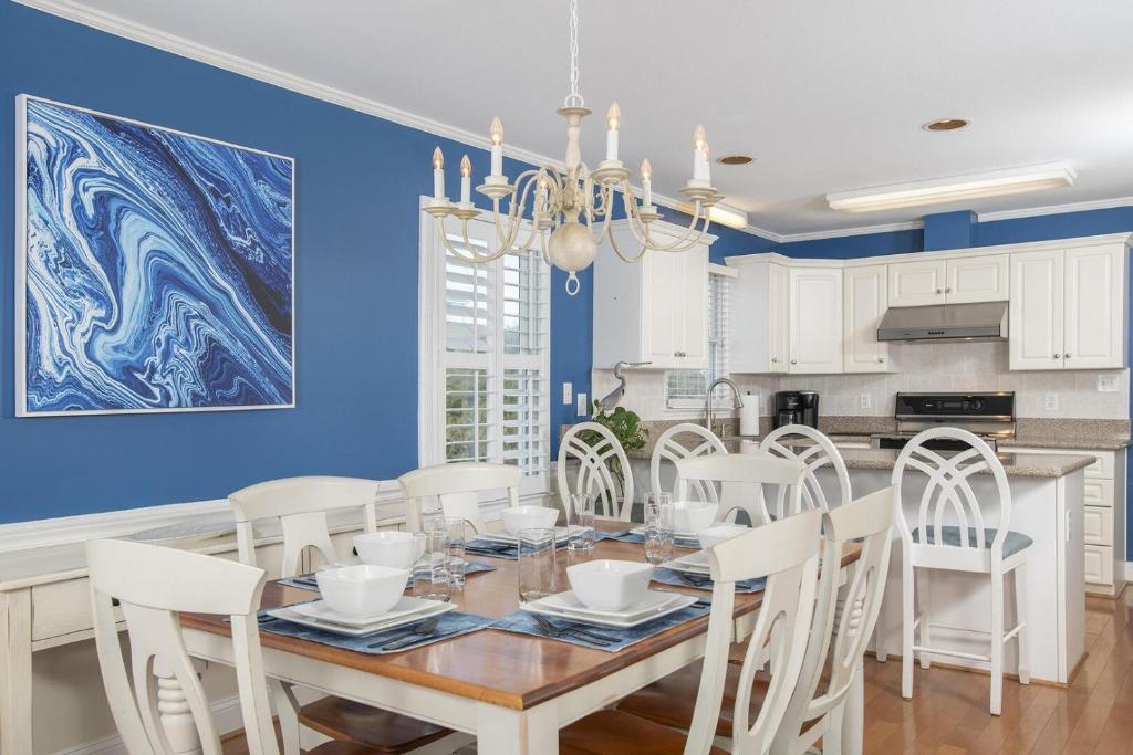 una sala da pranzo con pareti blu, tavolo e sedie di Azure home a Emerald Isle