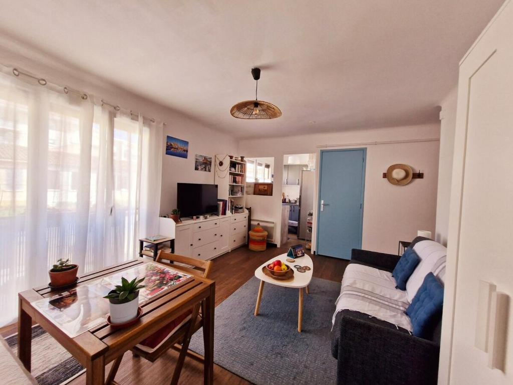 un salon avec un canapé et une table dans l'établissement Cosy T1 proche port La Ciotat, à La Ciotat