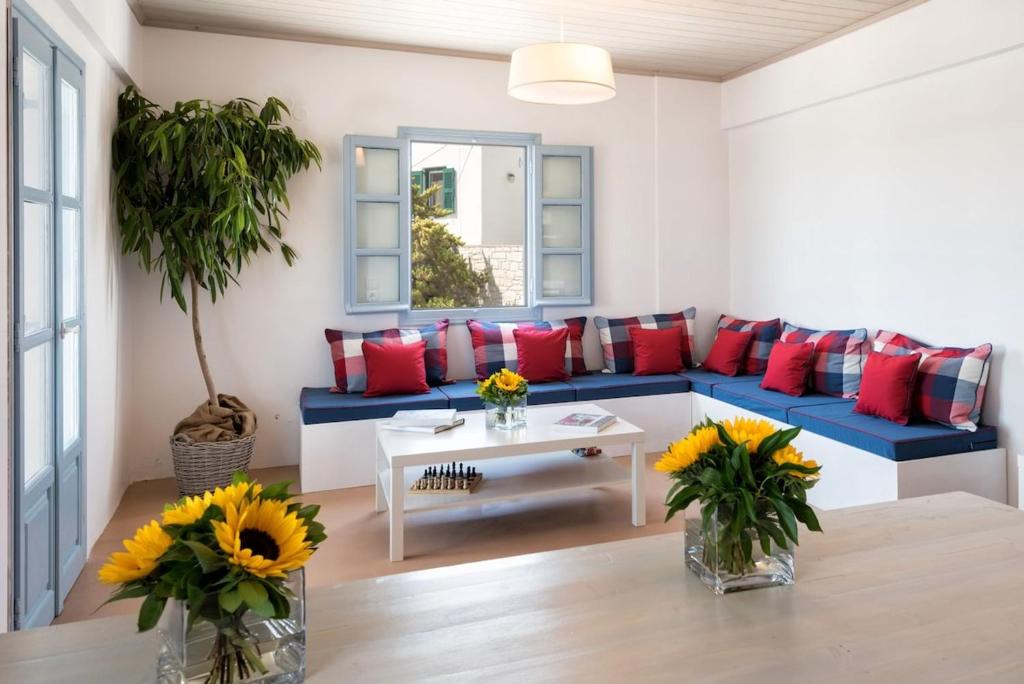 sala de estar con sofá azul y almohadas rojas en Menta I in the heart of Naousafree parkingParos, en Naousa