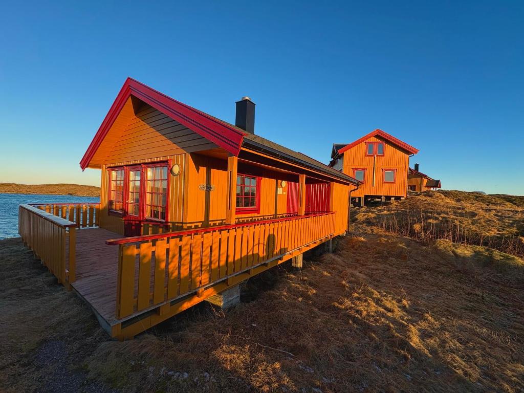 two houses on the shore of a beach at Helligvær Kystopplevelser AS in Helligvær