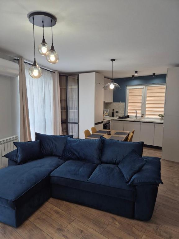 a living room with a blue couch and a kitchen at V&S apartments 1 in Sliven