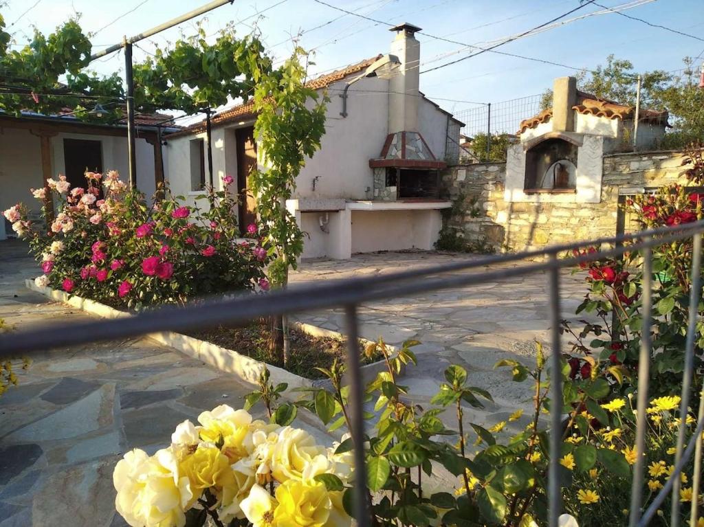 a house with flowers in front of a fence at Koeni House in Argalasti