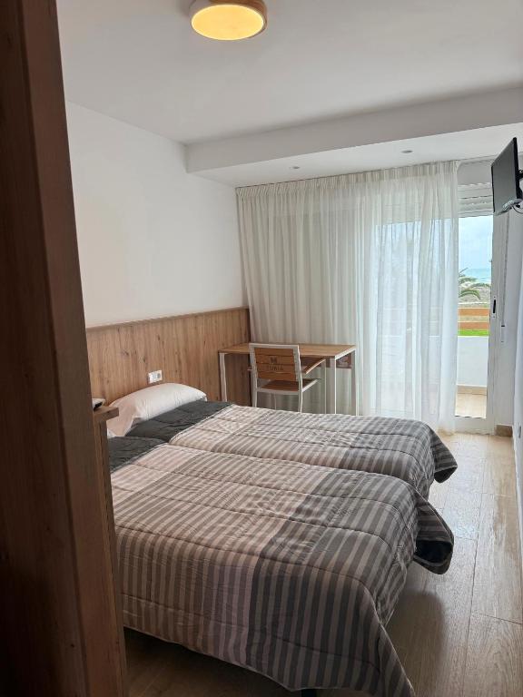 A bed or beds in a room at Pensión La Ola