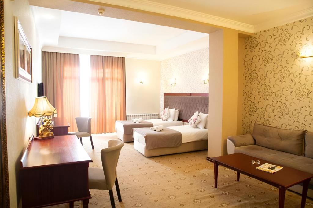 a living room with a couch and a bed and a table at Capitol Hotel Stay in Baku