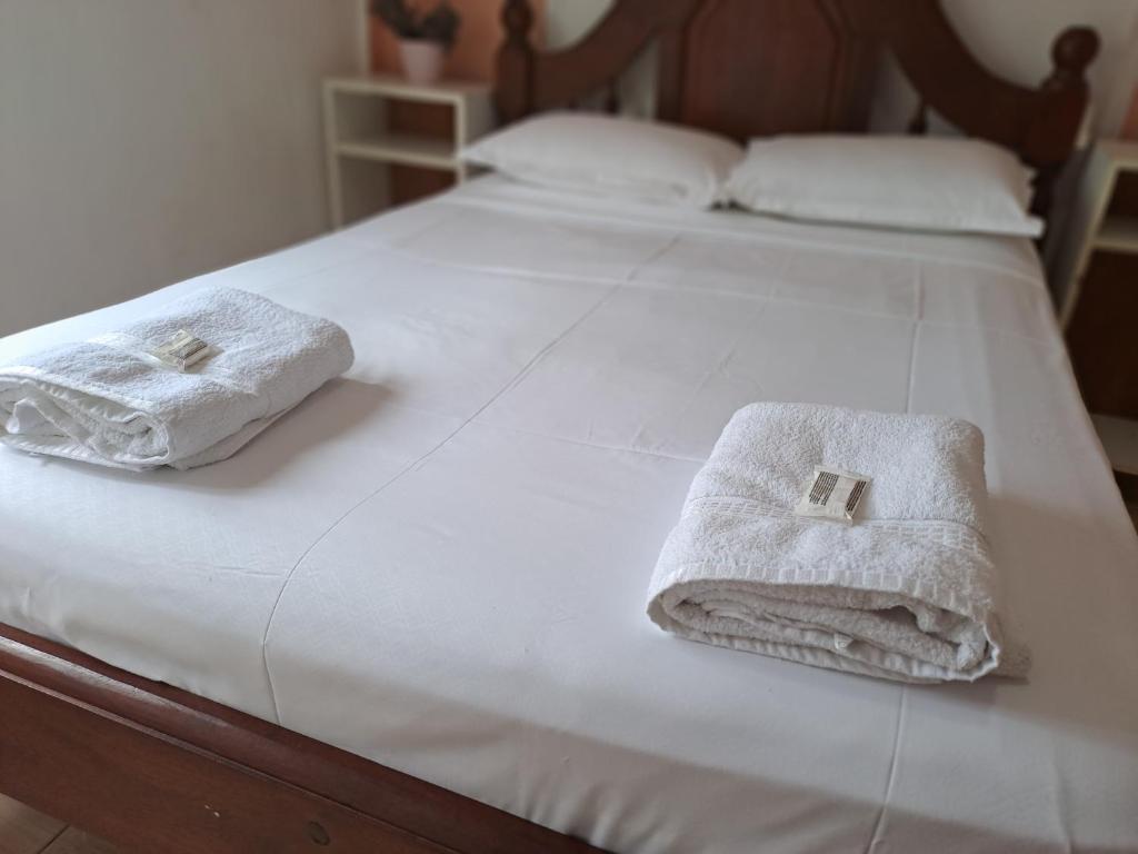 Zwei Handtücher liegen auf einem weißen Bett. in der Unterkunft Departamento don Pedro 1 in Posadas