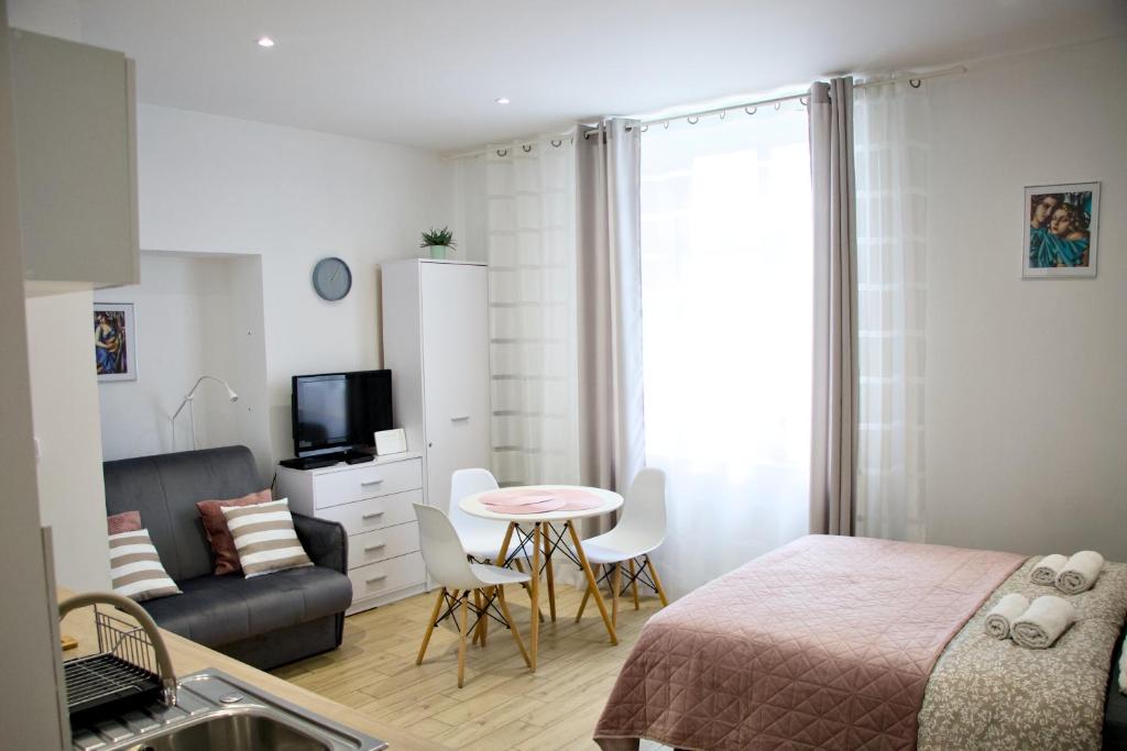 a bedroom with a bed and a table and a couch at Studio z widokiem na rzekę in Przemyśl