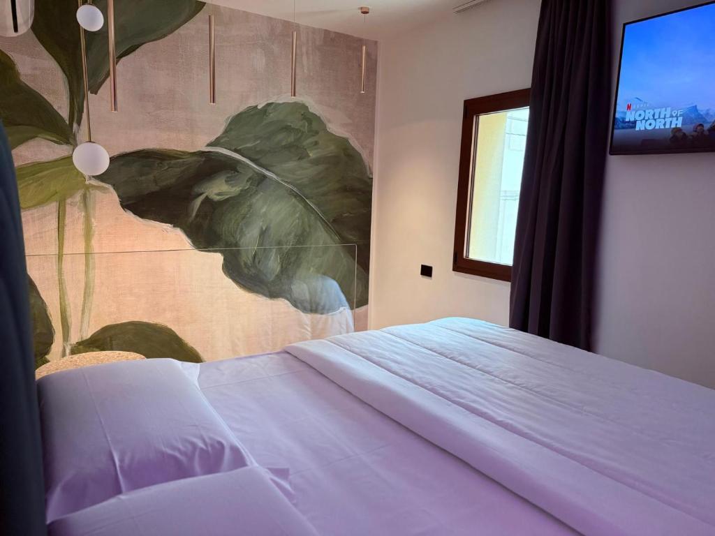 a bedroom with a bed with a painting on the wall at Krysos Luxury Rooms in Agrigento