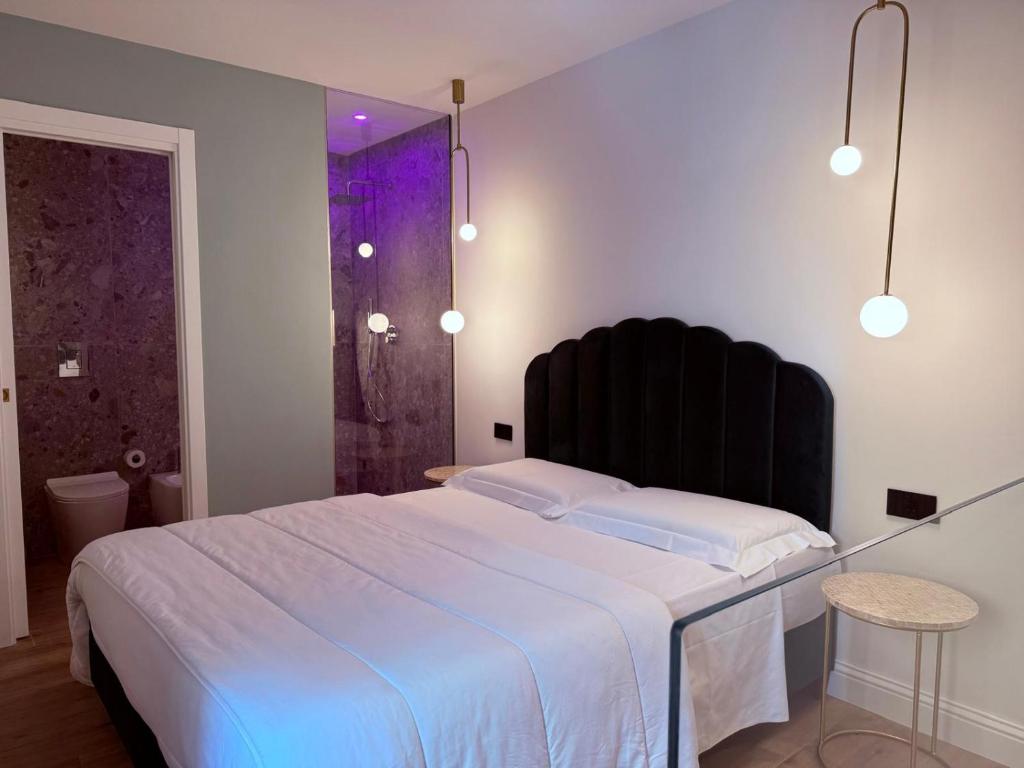 a bedroom with a large bed with a black headboard at Krysos Luxury Rooms in Agrigento