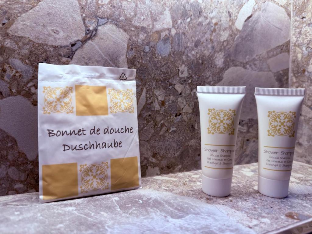 two bottles of deodorant sitting next to a bag at Krysos Luxury Rooms in Agrigento