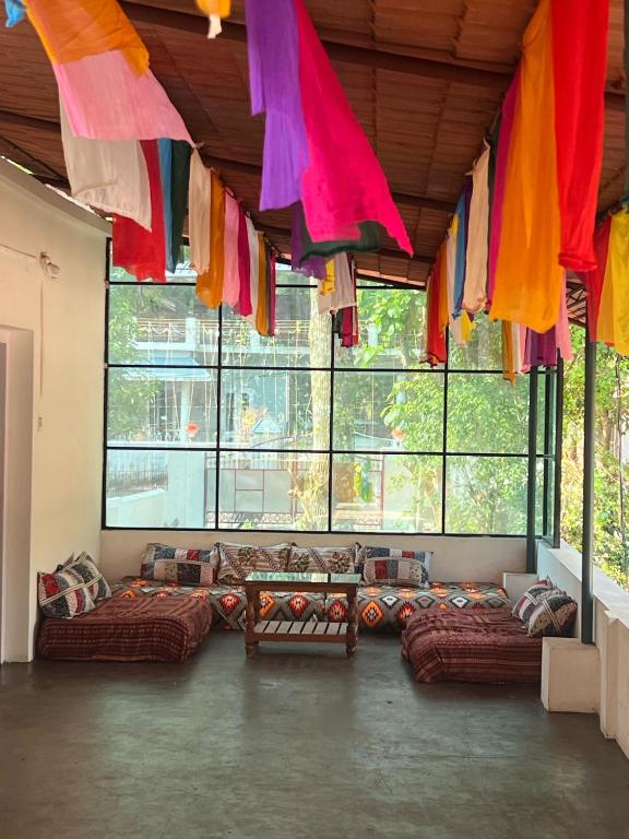 a large room with couches and flags hanging from the ceiling at Beach Bum Varkala in Varkala