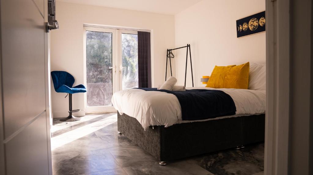 a bedroom with a bed and a blue chair at Luxury One Bedroom Flat - Cardiff City Centre in Cardiff
