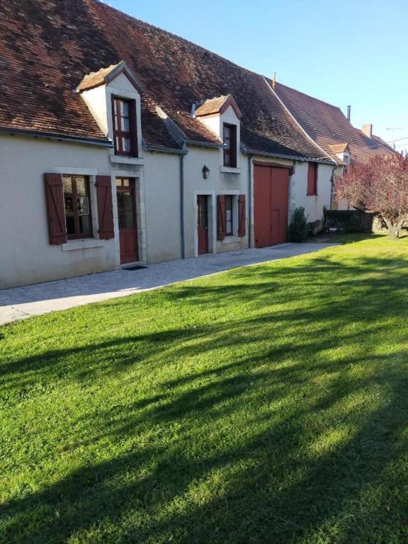 un groupe de maisons avec une grande cour gazonnée dans l'établissement Le Saulnier-Longère berrichonne, à Chasseneuil