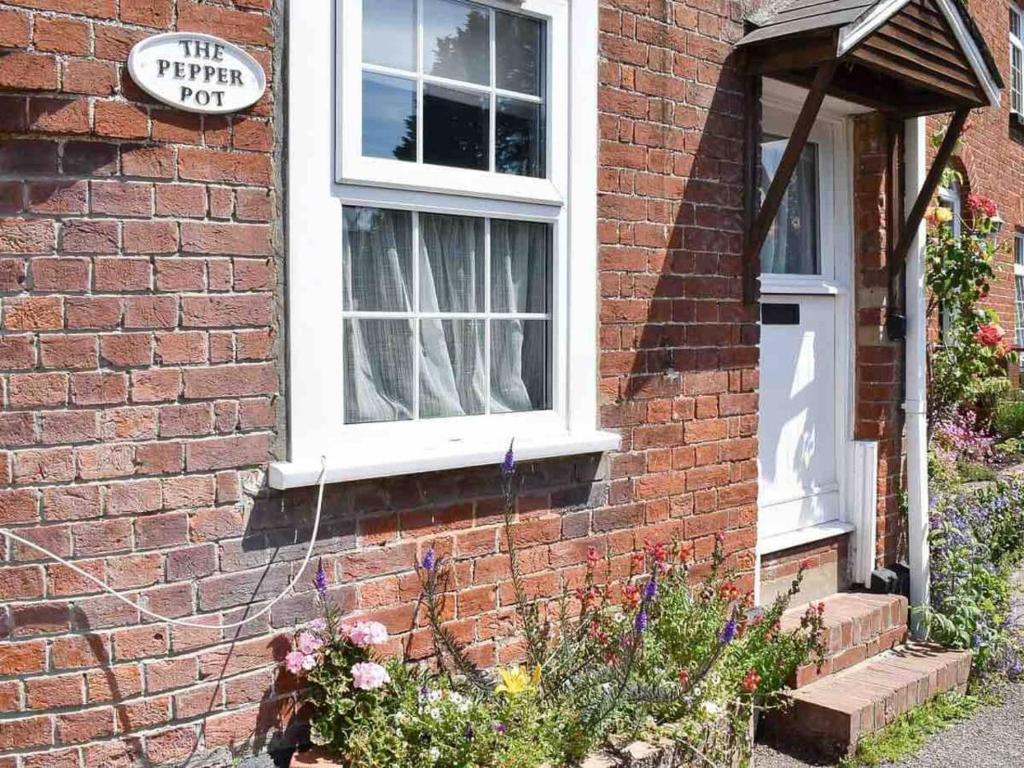 a brick house with a white window and a door at The Pepper Pot Sleeps 4 Sunlit Garden in Exmouth