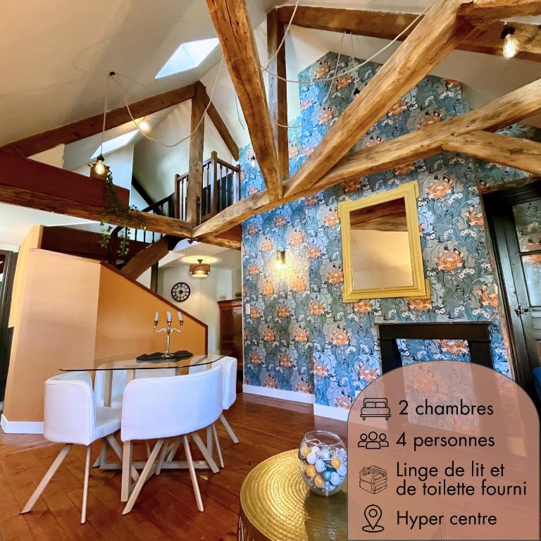 une salle à manger avec une table et un mur bleu dans l'établissement Le Gatsby - Duplex art déco au coeur de Blois, à Blois